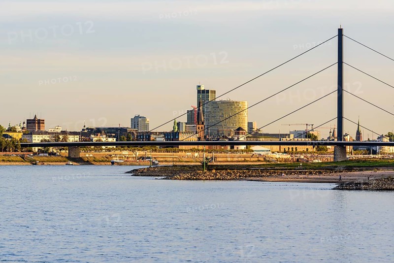 City scene with bridge and buildings on the riverbank under a clear sky shortly in front of sunset, Theodor-Heuss-Bruecke, Duesseldorf, North Rhine-Westphalia