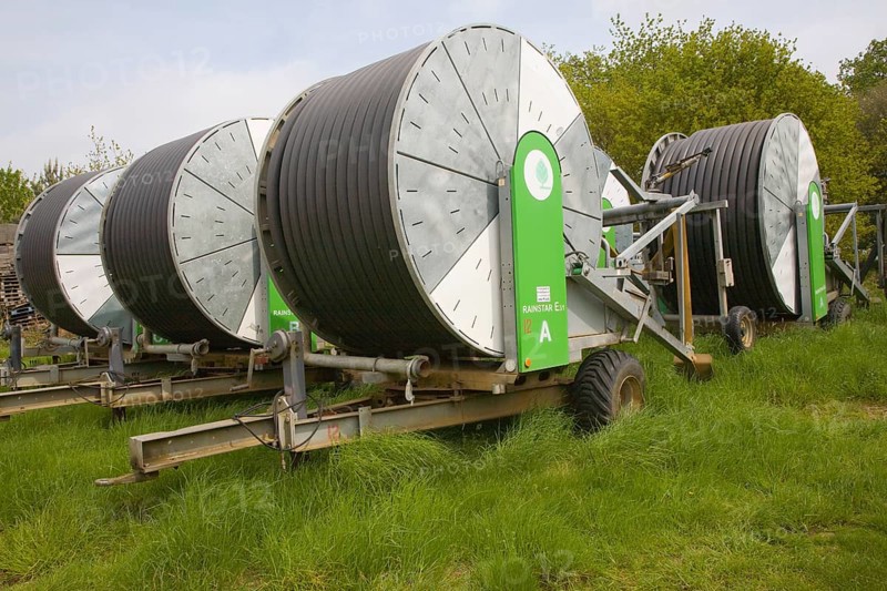 Rainstar irrigation crop sprayers stored in farm yard, Suffolk, England, United Kingdom, Europe