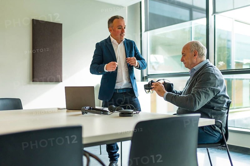 Businessman presenting a new innovative virtual reality goggles to a client in the office