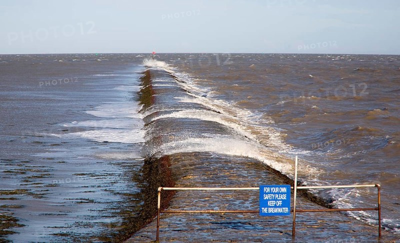 High seas forcing waves over the harbour mouth breakwater at Harwich, Essex, England, United Kingdom, Europe