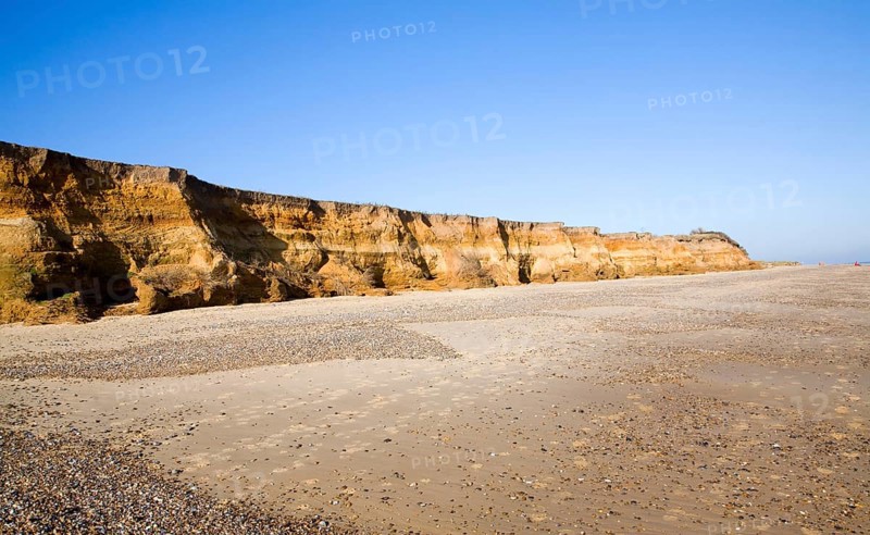 Rapid coastal erosion of soft cliffs between Benacre and Kessingland on the Suffolk coast England. The cliffs were formed by glacial outwash of sands and pebbles which overly older clay strata. This structure of permeable rock over impermeable clay makes the cliff especially prone to slumping and mass movement