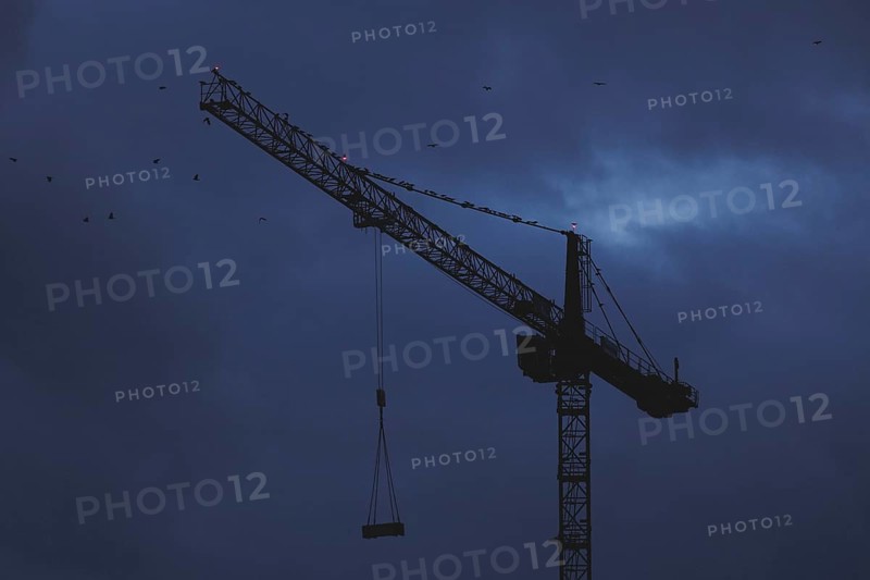A crane works at blue hour in Berlin, 20/02/2024