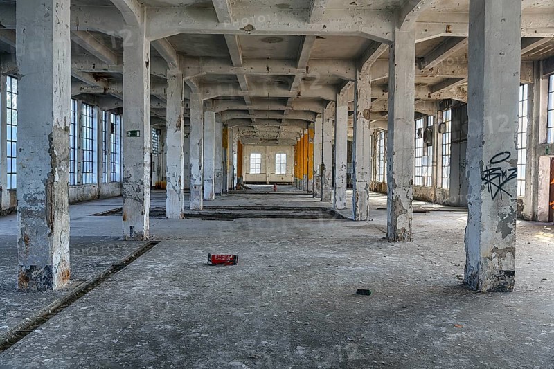 Empty dilapidated factory building, pillars, peeling paint, light entering through broken window panes, industrial ruin, interior shot, lost place, Germany, Europe