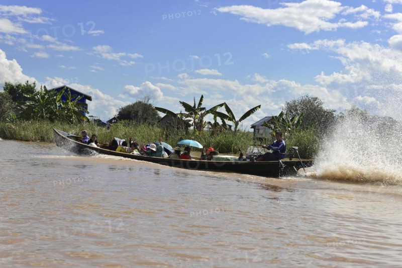 Long passenger boat travelling fast on a river and creating waves, Inle Lake, Myanmar, Asia