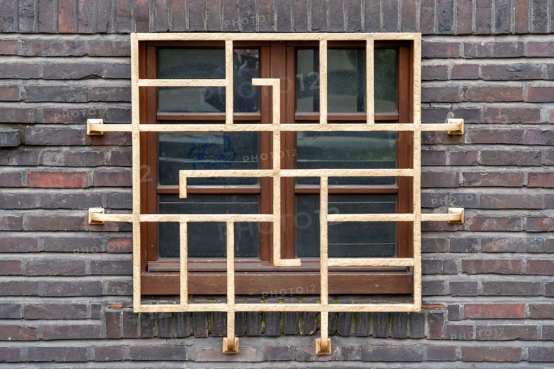 Lattice wooden window in Art Nouveau style, embedded in a brick wall