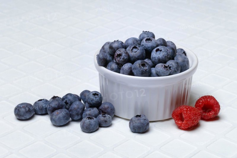 Blueberries in small bowls, raspberries