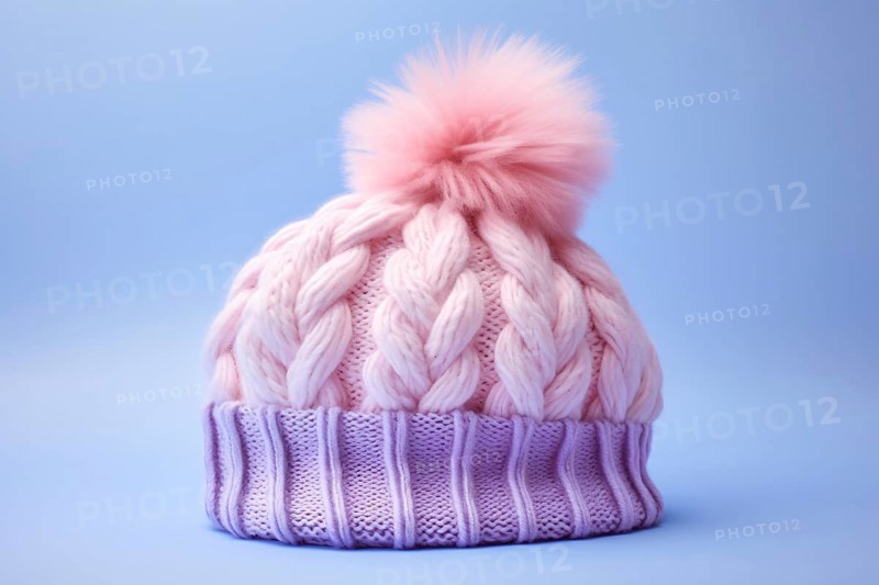 Pink and purple knitted winter hat with pompom on pastel blue background. KI generiert, generiert AI generated