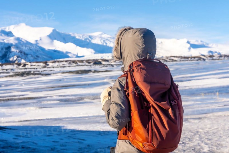 A woman on her back in winter Iceland on the Breidarlon glacier next to Jokulsarlon