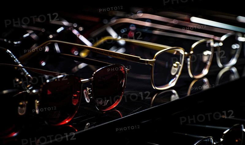 Assorted sunglasses on a reflective surface with a dark background AI generated