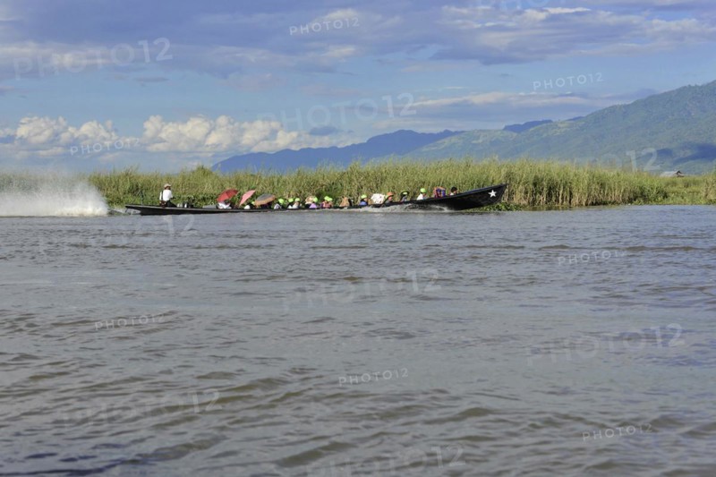 Group of people in a long boat on calm water, Inle Lake, Myanmar, Asia