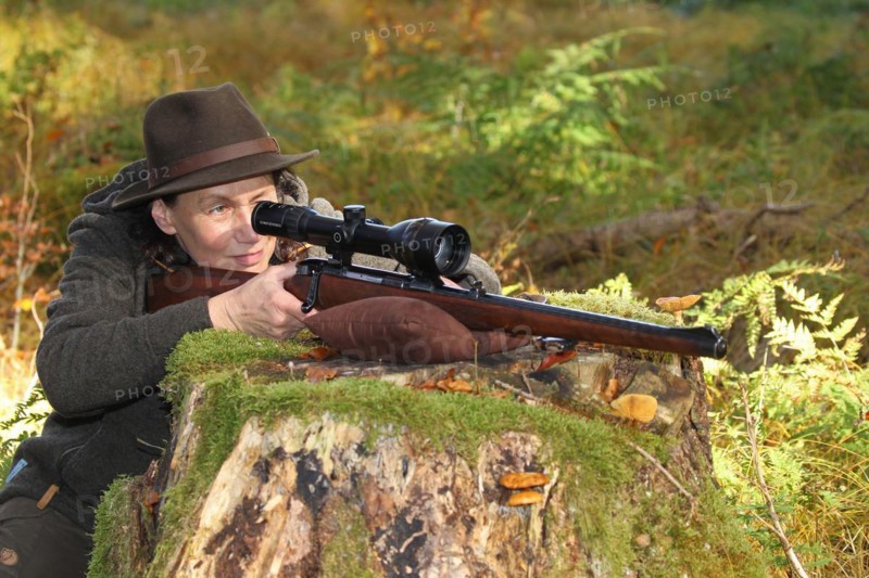 Huntress aims rifle with telescopic sight, Allgaeu, Bavaria, Germany, Europe
