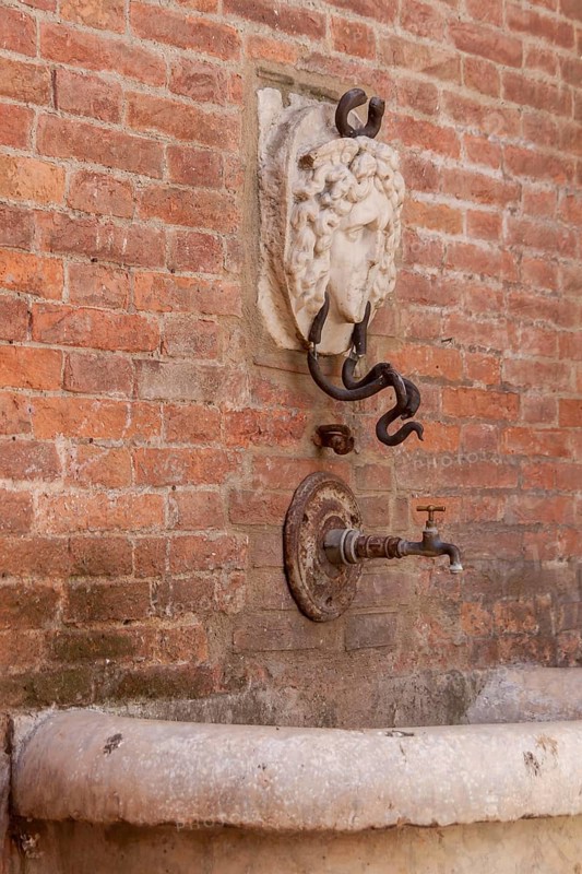Detail of the Mencia Fountain in the historic centre of Asciano, Crete Senesi, Tuscany, Italy, Europe