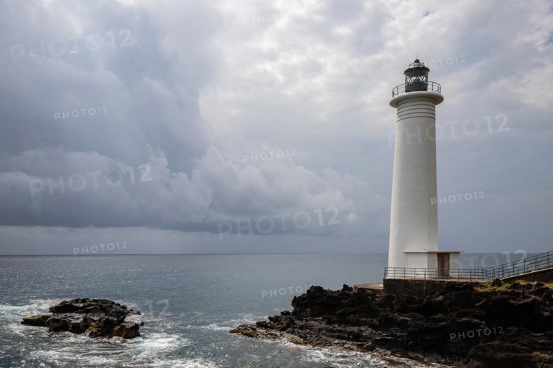 White lighthouse on a steep coast. Dramatic clouds with a view of the sea, pure Caribbean at Le Phare du Vieux-Fort, on Guadeloupe, French Antilles, France, Europe