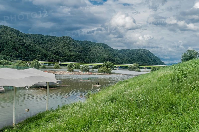Landscape of flooded baseball diamond and island of trash floating on surface of water after torrential monsoon rains in Daejeon South Korea