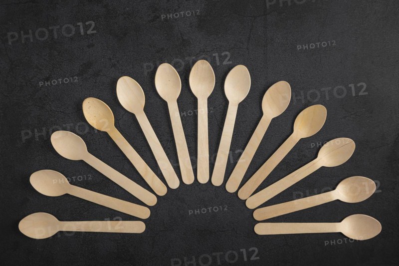 Fan-shaped arrangement of wooden spoons on a dark background