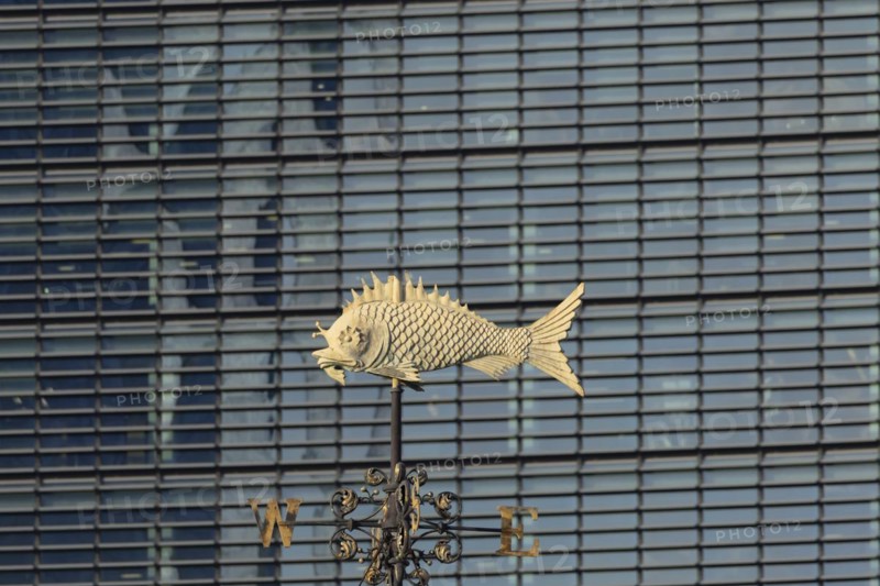 Fish weather vain in front of a high rise office skyscaper building, City of London, England, United Kingdom, Europe
