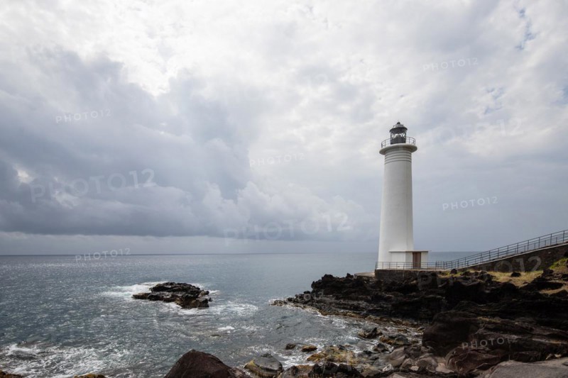 White lighthouse on a steep coast. Dramatic clouds with a view of the sea, pure Caribbean at Le Phare du Vieux-Fort, on Guadeloupe, French Antilles, France, Europe