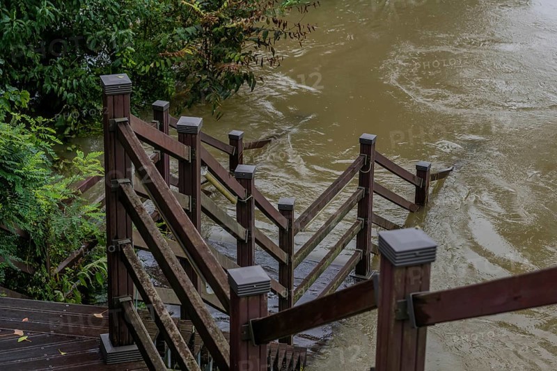 Wooden staircase leading to boardwalk submerged in river after torrential monsoon rains in Daejeon South Korea