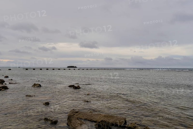 Seascape of the pacific ocean with a rocky shoreline taken in Guam on a cloudy day in Guam