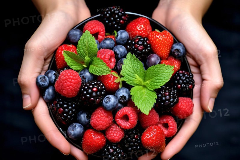 Top view of woman's hands holding bowl with fruit berry mix on dark background. KI generiert, generiert AI generated