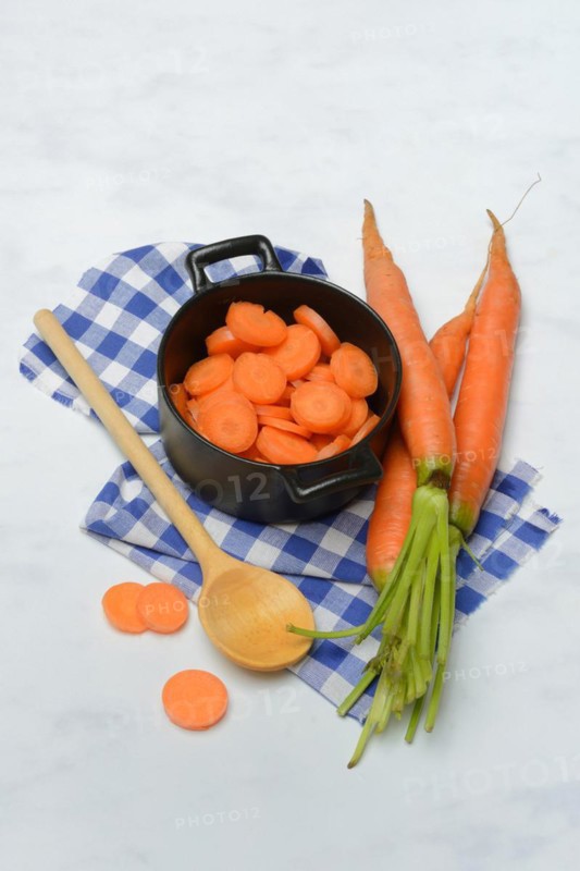 Carrot slices in pots and wooden spoon, carrot (Daucus carota)
