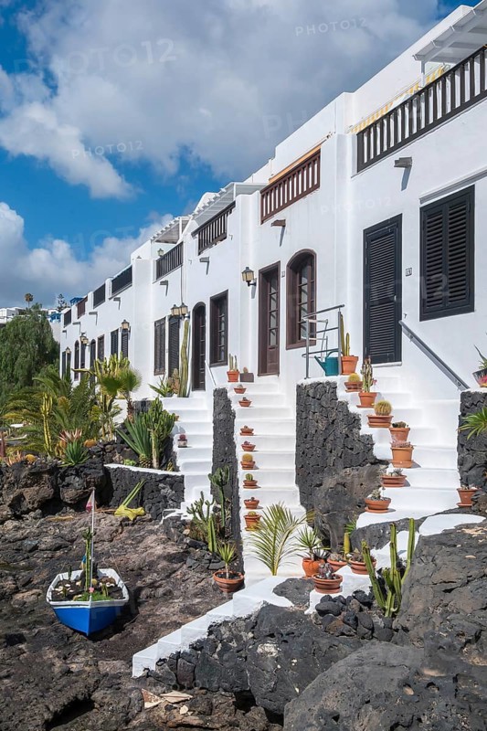 Typical white houses with small gardens on lava rock, on the promenade of Puerto del Carmen, Lanzarote, Canary Islands, Spain, Europe