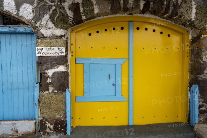 Yellow garage door in stone wall, climate, Milos, Cyclades, Greece, Europe