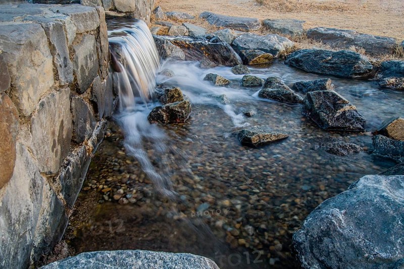 Daylight reveals the dynamic flow of a small rocky waterfall, in South Korea