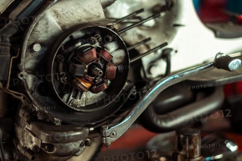 Close-up of a classic italian vintage scooter motorcycle engine's stator assembly in a workshop setting