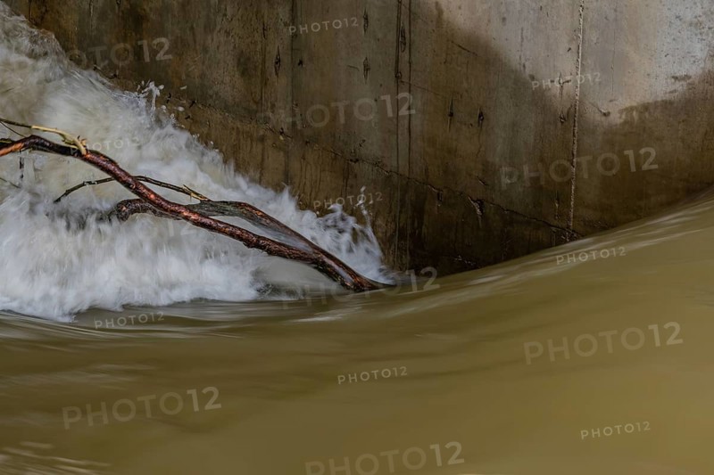 Tree branch held next to dam's support column by surging water through floodgate in Daejeon South Korea
