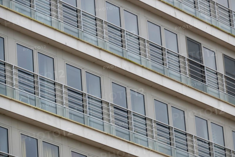 Symmetrical view of residential balconies with glass railings and white frames, Blankenberge, Flanders, Belgium, Europe