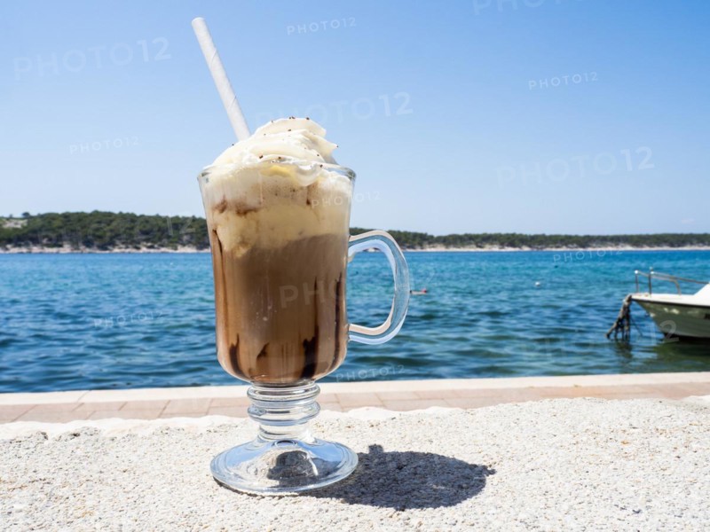 Iced coffee with whipped cream, the sea in the background, Rab Island, Kvarner Gulf Bay, Croatia, Europe