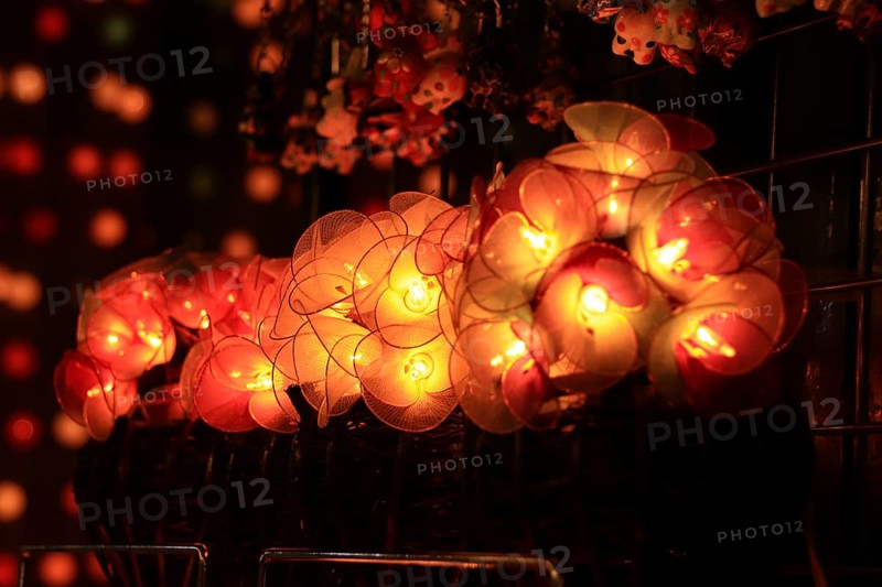 Glowing round paper lanterns on display at a market with soft, warm lighting and bokeh background. Chiang mai, Thailand, Asia