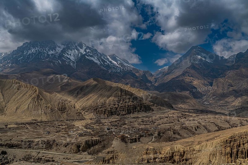 Desert landscape before a snowcapped mountain range, Kingdom of Mustang, Nepal, Asia