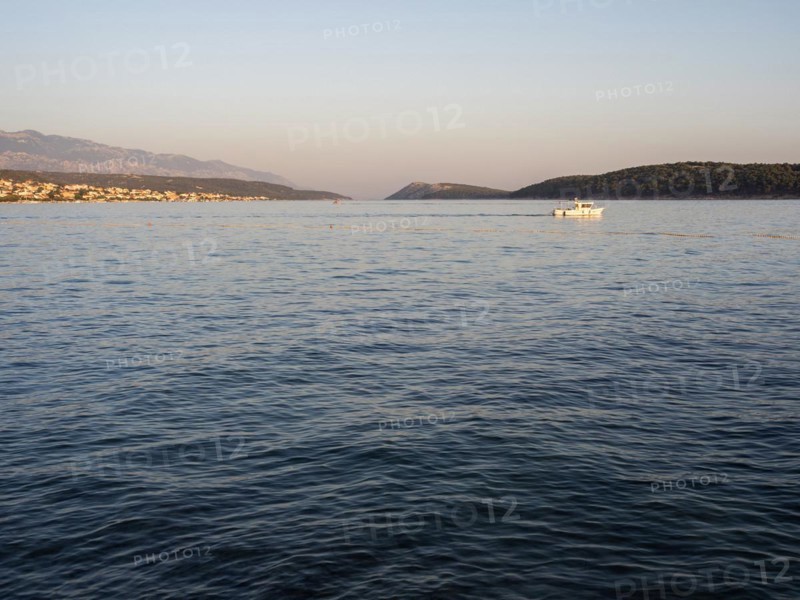 Boat leaving a bay in the evening light, island of Rab, Kvarner Gulf Bay, Croatia, Europe