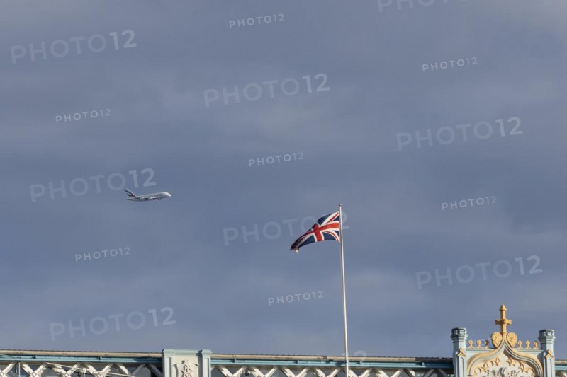 Airbus A380 aircraft of Emirates airlines in flight with a Union Jack flag on Tower Bridge in the foreground, London, England, United Kingdom, Europe