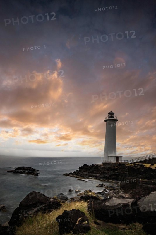White lighthouse on a steep coast. Dramatic clouds with a view of the sea, pure Caribbean at Le Phare du Vieux-Fort, on Guadeloupe, French Antilles, France, Europe
