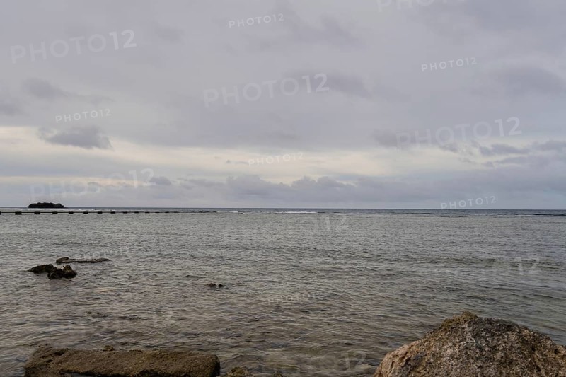 Seascape of the pacific ocean with a rocky shoreline taken in Guam on a cloudy day in Guam