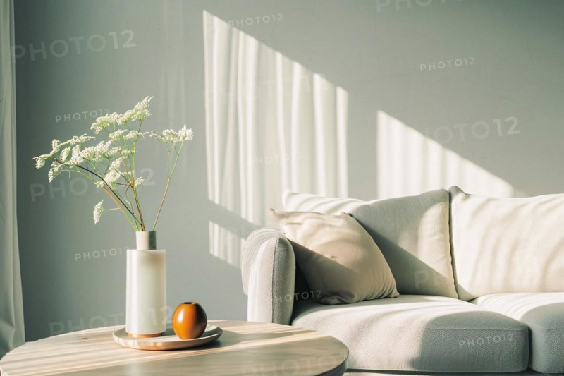 A tranquil corner with a sofa, a vase of flowers casting soft shadows on the wall, AI generated