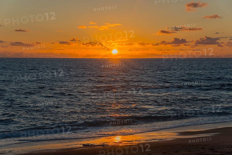 Dramatic sunset over the sea with radiant light and reflections on the water, Finikounda, Pylos-Nestor, Messinia, Peloponnese, Greece, Europe