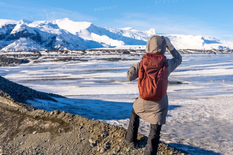 A woman visiting Iceland in winter on the Breidarlon glacier next to Jokulsarlon