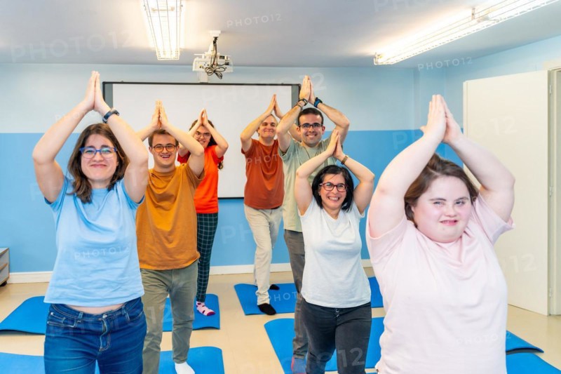 Disabled group of people practicing yoga together in a gym with good vibes