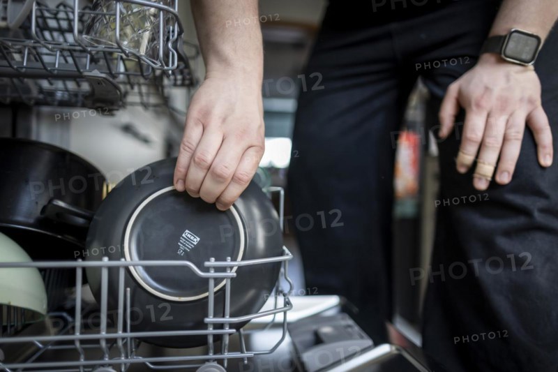 A man loads a dishwasher. Berlin, 08.03.2024