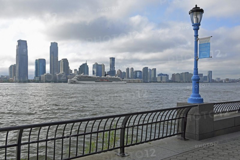 Street lamp marking the potential future flood level caused by global warming, in the background skyline of Jersey City, Hudson River, Lower Manhattan, New York City, New York, USA, North America