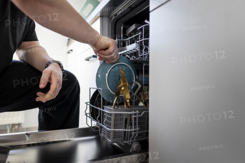 A man loads a dishwasher. Berlin, 08.03.2024
