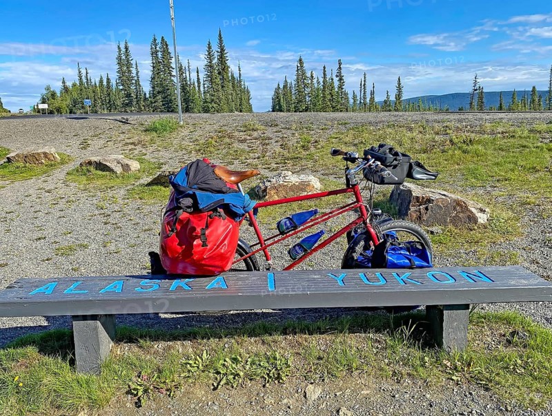 Bench right on the border between Alaska and the Yukon, packed touring bike, adventure travelling, Alaska Highway, Yukon Territory, Canada, North America