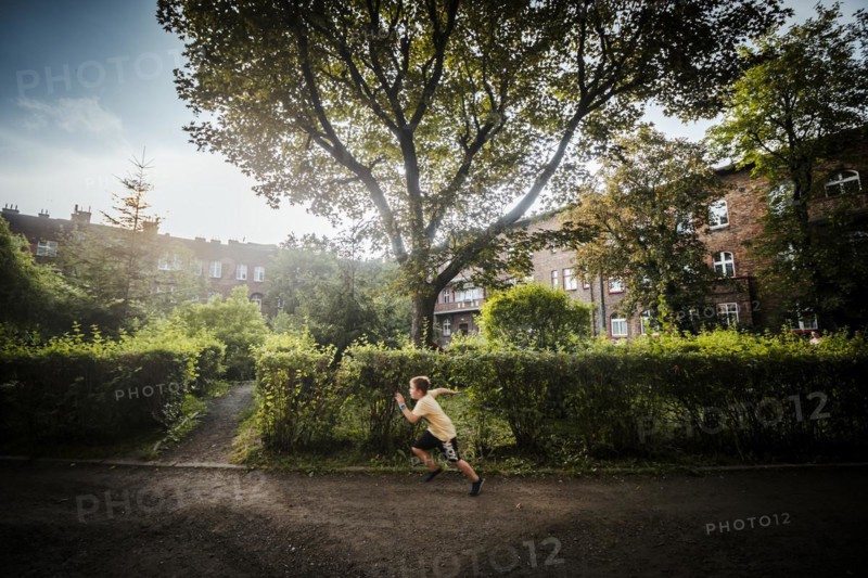 Nikiszowiec, Poland, 14 April 2020: A boy running through green courtyard in the mining district of Katowice, Silesia, Europe