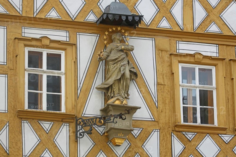 Madonna figure with halo on a yellow half-timbered house, detail, house wall, window, yellow, main street, Ochsenfurt, Lower Franconia, Franconia, Bavaria, Germany, Europe