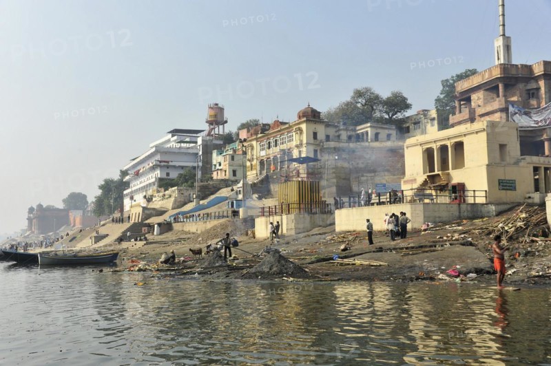 Urban riverbank with people living everyday life, framed by a culturally rich urban landscape, Varanasi, Uttar Pradesh, India, Asia