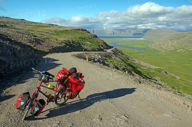 Packed bike standing on a gravelled track leading out into a wide valley, Adventure travel, Cycle tourism, Latrabjarg, Iceland, Europe